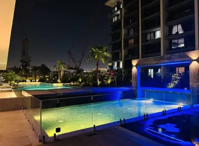 a swimming pool with blue lights in a building at Stylish Dubai Hills Studio with Rooftop Pool and Gym in Dubai