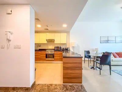 a kitchen and living room with a table and chairs at Chic Stay in Sparkle Towers in Dubai