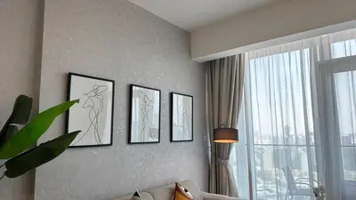 a living room with four pictures on the wall at Modern & Fully Furnished 1BR in Heart of JVC in Dubai