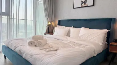 a bed with towels and a remote control on it at Modern & Fully Furnished 1BR in Heart of JVC in Dubai