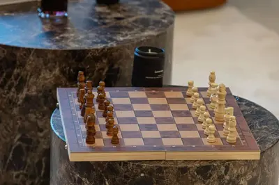 a chess board on a table next to a drink at Prime Downtown Location 2BR Walk to Dubai Mall in Dubai