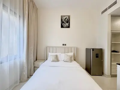 a bedroom with a large white bed and a window at Signature Vista Studio Apartment in Dubai
