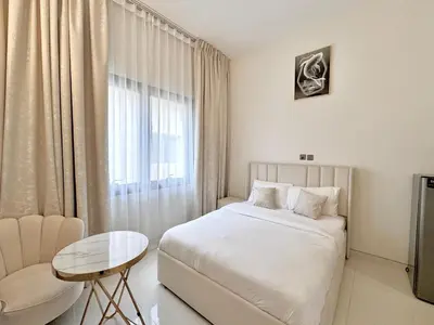 a bedroom with a bed and a table and a window at Signature Vista Studio Apartment in Dubai
