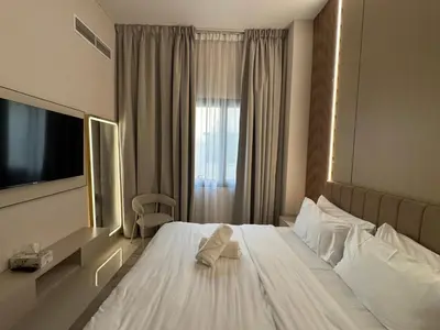 a hotel room with a large bed and a television at Signature Grand Studio Apartment in Dubai