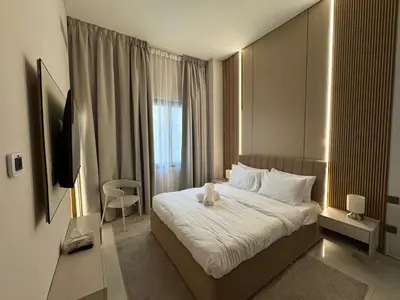 a hotel room with a bed and a television at Signature Grand Studio Apartment in Dubai