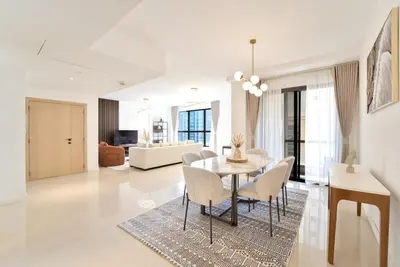a dining room and living room with a table and chairs at Elegant and Spacious 3-bedroom in JBR in Dubai