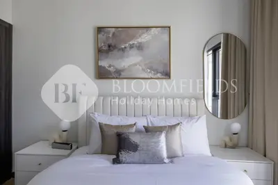 a bedroom with a white bed and a mirror at Bloomfields Cozy 1br In Rukan in Dubai