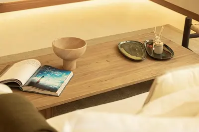 a table with a book and a vase on a bed at Premium Corner 3BR, Sea Views with Sunset, 85 inch TV in Dubai