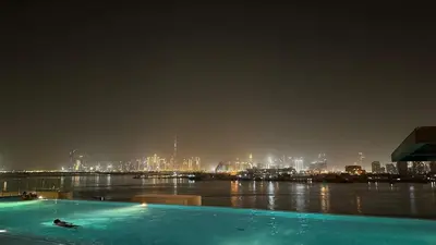 a swimming pool with a view of a city at night at Silkhaus Lavish 2BDR Retreat at Dubai Creek Harbour in Dubai