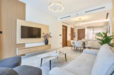 a living room with a couch and a tv and a table at STAY BY LATINEM Luxury 2 BR Plus Maid Holiday Home CD 0208 Near Burj Khalifa in Dubai