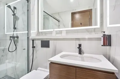 a white bathroom with a sink and a shower at STAY BY LATINEM Luxury 2 BR Plus Maid Holiday Home CD 0208 Near Burj Khalifa in Dubai
