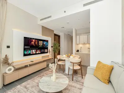 a living room with a couch and a tv at Royal Vista - Stunning Boho Style 1BR with 5 Star Amenities in Dubai