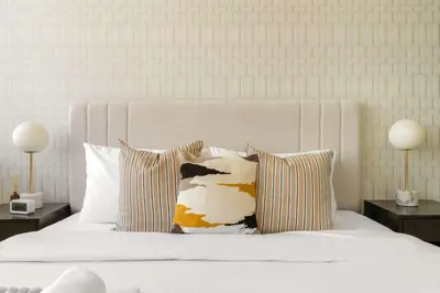 a white bed with two pillows and two lamps at Silkhaus Classic 1BDR in DIFC at Sky Gardens in Dubai