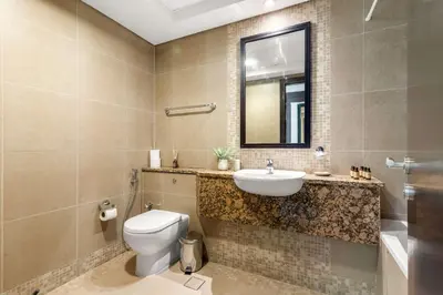 a bathroom with a toilet and a sink and a mirror at Silkhaus Classic 1BDR in DIFC at Sky Gardens in Dubai