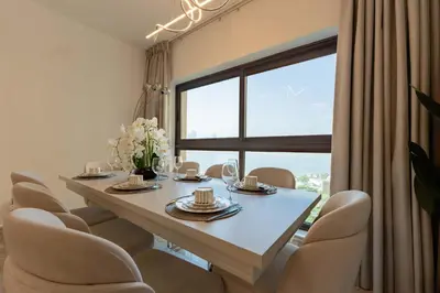 a dining room with a table and chairs and a large window at TRPS - Fairmont North Residences, Palm Jumeirah - Luxurious 2BR plus Maids, Sea and Harbour View in Dubai