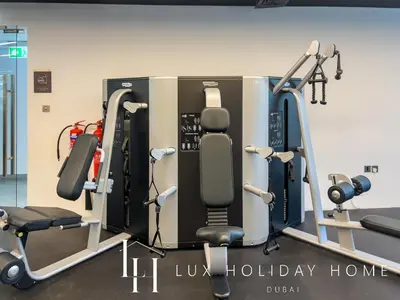 a gym with several treadmills and weights at LUX LIV Contemporary Marina View Suite 2 in Dubai
