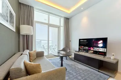 a living room with a couch and a flat screen tv at FAM Living - 1 Bedroom Canal View in DAMAC Maison Prive in Dubai