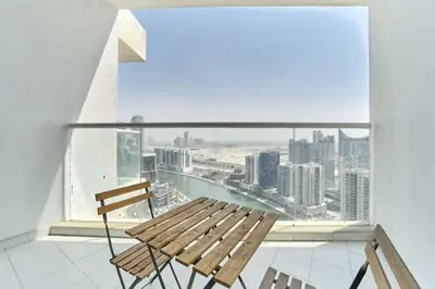 a wooden bench in a room with a large window at FAM Living - 1 Bedroom Canal View in DAMAC Maison Prive in Dubai