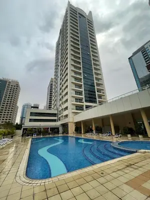 a swimming pool in front of a tall building at Marina View Towers - Dubai Marina Walk Access - View - 1BHK - Marsa in Dubai
