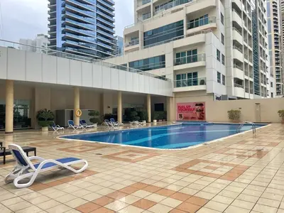 a swimming pool in a building with chairs and a building at Marina View Towers - Dubai Marina Walk Access - View - 1BHK - Marsa in Dubai