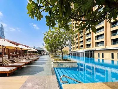 a swimming pool with tables and chairs next to a building at PVH - Burj Khalifa View Studio - Emaar Residences in Dubai