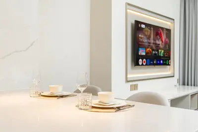 a table with two plates and glasses and a tv at PVH - Burj Khalifa View Studio - Emaar Residences in Dubai
