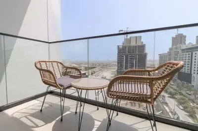 two chairs and a table on a balcony with a view at StayShort - Perfect Studio in Binghatti Azure JVC - Sleeps 2 in Dubai