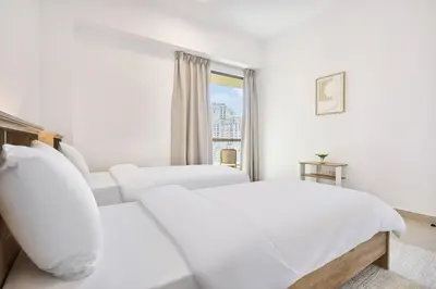 a white bedroom with a white bed and a window at Modern 3BR in Rimal 5, JBR Dubai in Dubai