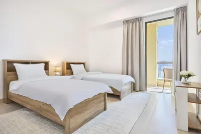 two beds in a hotel room with a balcony at Modern 3BR in Rimal 5, JBR Dubai in Dubai