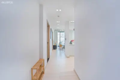 a hallway of a house with white walls and wooden floors at Modern Brand New 1BR Luxury Apartment With Cozy Interiors In Jumeirah Village Circle in Dubai