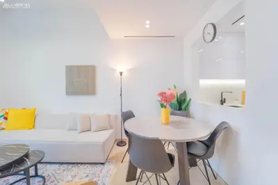 a living room with a white couch and a table at Modern Brand New 1BR Luxury Apartment With Cozy Interiors In Jumeirah Village Circle in Dubai