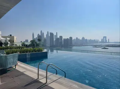 a swimming pool with a city skyline in the background at Azure Palm in Dubai