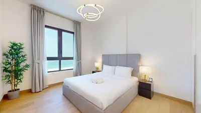 a bedroom with a white bed and a large window at Locations l Upgraded 1 Bedroom l Sea Views, Beach Access l Port de La Mer in Dubai