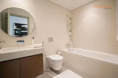 a bathroom with a sink and a toilet and a mirror at Private Beach Access with Luxury Beachfront Lifestyle in Dubai