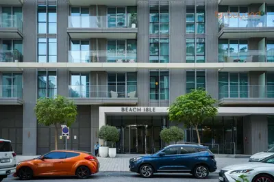 two cars parked in a parking lot in front of a building at Private Beach Access with Luxury Beachfront Lifestyle in Dubai