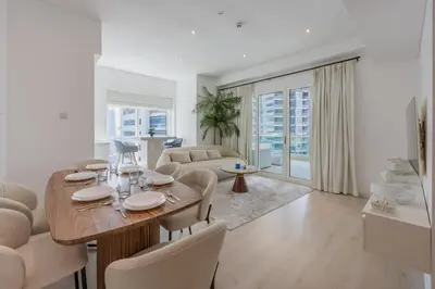 a living room with a wooden table and chairs at Modern Luxury Marina Stay with Ain Dubai View - Near JBR Beach in Dubai
