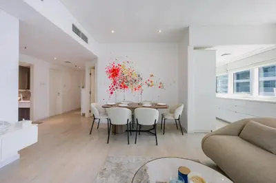 a living room with a dining room table and a kitchen at Modern Luxury Marina Stay with Ain Dubai View - Near JBR Beach in Dubai