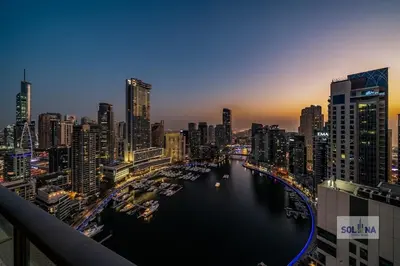a view of a river in a city at night at Waterfront 1BR Apartment At Heart of Dubai Marina in Dubai