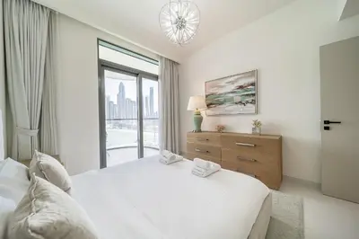 a white bedroom with a large bed and a window at Modern 2BR Retreat with Stunning Sea Views in Dubai