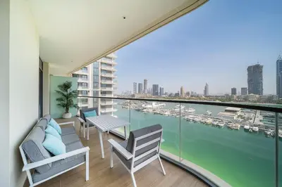a balcony with chairs and a view of a harbor at Modern 2BR Retreat with Stunning Sea Views in Dubai
