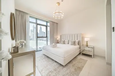 a white bedroom with a bed and a large window at Modern 2BR Retreat with Stunning Sea Views in Dubai