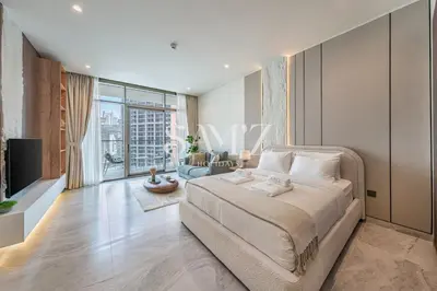 a bedroom with a large bed and a living room at Cozy Studio - Unit 1807 - Peninsula Five in Dubai