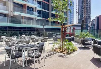 a patio with tables and chairs on a building at Cozy Studio - Unit 1807 - Peninsula Five in Dubai