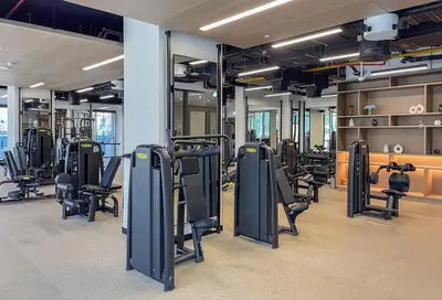 a gym with rows of exercise bikes and treadmills at Cozy Studio - Unit 1807 - Peninsula Five in Dubai
