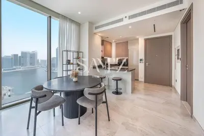 a kitchen and living room with a table and chairs at Sleek 1BR Gem - Unit 1709 - Peninsula Five in Dubai