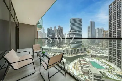 a balcony with chairs and a view of a city at Sleek 1BR Gem - Unit 1709 - Peninsula Five in Dubai