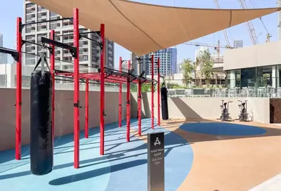 a gym with red and black equipment on top of a building at Sleek 1BR Gem - Unit 1709 - Peninsula Five in Dubai