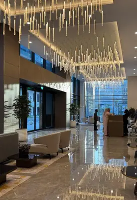 a lobby with a large chandelier in a building at Sleek 1BR Gem - Unit 1709 - Peninsula Five in Dubai