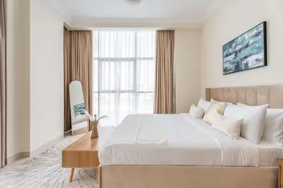 a bedroom with a large bed and a large window at Chic 1BR w Pool Sauna & Steam Room Access in Dubai