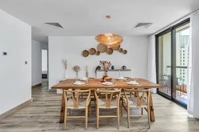 a dining room with a wooden table and chairs at GYL Holiday Homes I Spacious 4 BDR Apt in JBR Beach, Dubai eye & Marina I Unbeatable location in Dubai